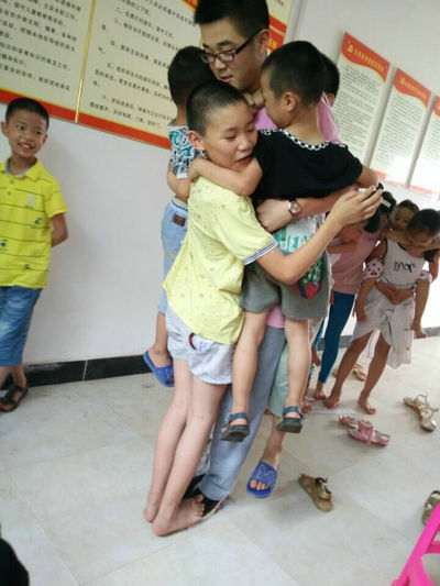 1472368299956639.jpg 志愿者和孩子玩游戏.jpg